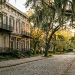 Cobblestone street lined with antebellum row houses and Spanish moss-draped live oak trees in Savannah Georgia historic district