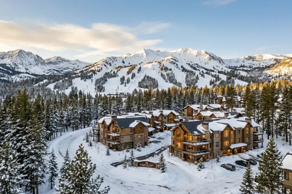 Snow-covered resort condominiums in Mammoth Lakes California with Mammoth Mountain and Eastern Sierra peaks in the background