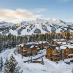 Snow-covered resort condominiums in Mammoth Lakes California with Mammoth Mountain and Eastern Sierra peaks in the background