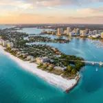 Aerial view of Sarasota Florida Gulf Coast showing barrier islands, white sand beaches, and waterfront vacation rental properties at golden hour