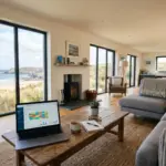 Vacation rental property interior with laptop showing booking analytics, representing the Airbnb vs VRBO host comparison for 2026