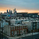 City skyline with residential neighborhood and World Cup stadium showing enforcement tension between housing and major event infrastructure