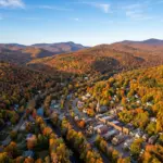 Aerial view of the Catskill Mountains in autumn showing fall foliage and mountain town