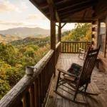 A warm vacation rental cabin porch with rocking chair overlooking mountain forest views at golden hour